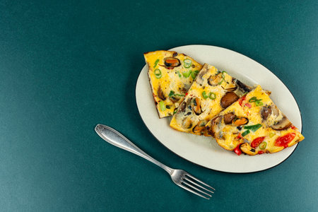 A delicious mussels frittata garnished with vegetables.の写真素材
