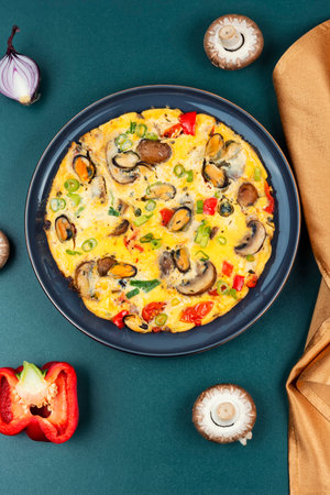 Breakfast omelet with mussels, mushrooms and vegetables. Healthy food conceptの写真素材