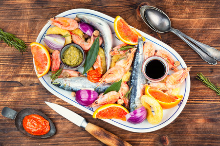 Preparing seafood with spices and citrus fruits on wooden rustic background. The concept of cooking, marinating fish.の写真素材