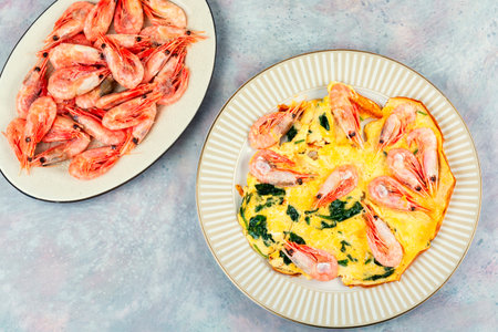 Appetizing egg omelette with shrimps and fresh spinach. Free space for your text.の写真素材