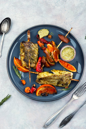 Grilled pollock or cod fillet with citrus and pesto sauce. Grilled fish, seafood.