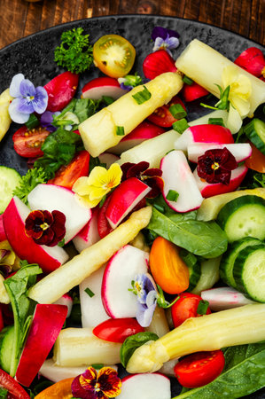 Salad with white asparagus, cucumbers, tomatoes and edible flowers.の写真素材