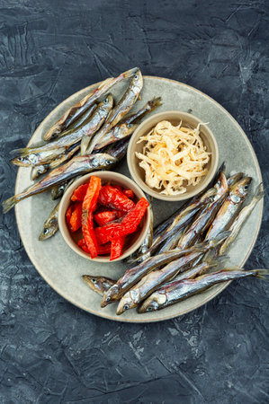 Dried fish, dried salmon, and dried squid served on a plate.の写真素材