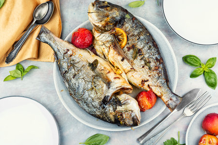 Dorado roasted with seasonal fruits plums. Diet, cooked sea bream fish. Flat layの写真素材