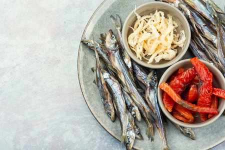 Beer and assorted dried fish on a cooking sheet, traditional beer snack. Smoked salmon for beer. Copy space.の写真素材