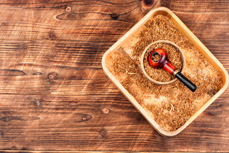 Elegant tobacco pipe filled with dried tobacco leaves. Concept of relaxing, smoking pipe. Space for text.の写真素材