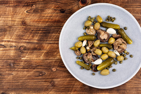Appetizing snacks of salted cucumbers, marinated mushrooms and olives. Copy space.の写真素材