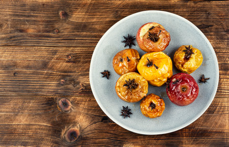 Traditional baked apples dessert with whole spices, perfect for autumn and winter menu. Rustic style.の写真素材
