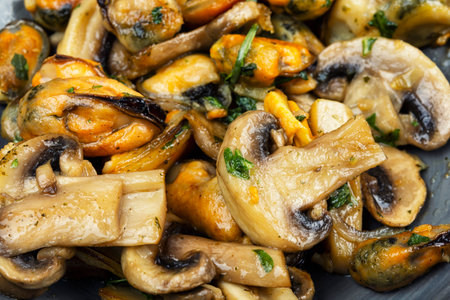 A delicious salad of peeled and fried mussels and mushrooms in a garlic sauce.の写真素材