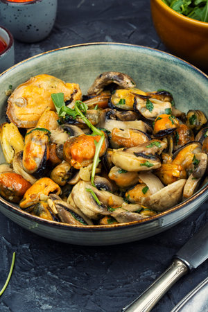 Warm salad with mussels and mushrooms coated in a light garlic sauce. Homemade seafood dish.の写真素材