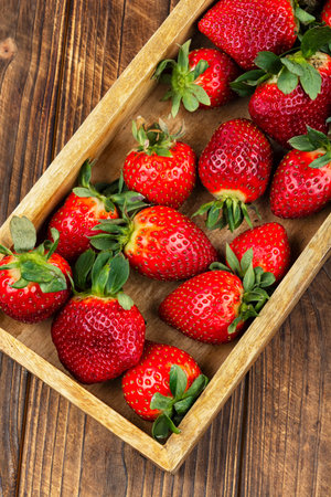 Ripe fresh strawberries in a wooden crate, natural farm produce, organic fruit and seasonal harvest concept.の写真素材