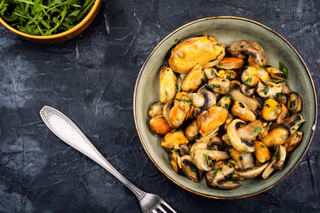 A plate of crispy fried mussels garnished with herbs and roasted champignon mushrooms.の写真素材