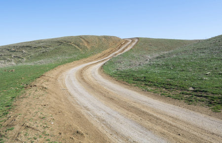   1057,ountry road in the field, leading to the mountain topの写真素材