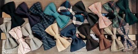 colored bow ties lie on a wooden brown shelfの写真素材