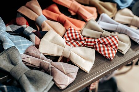 elegant colored bow ties lie on a wooden brown shelf in warm colorsの写真素材