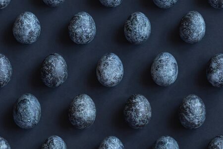 Unusually painted Easter dark eggs are staggered in a dark backgroundの写真素材