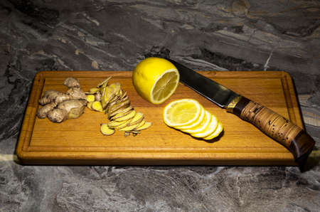 Thinly sliced ginger and lemon on a wooden cutting board. Ingredients for delicious and healthy teaの写真素材