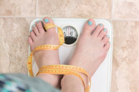 image of woman standing on a weight scale