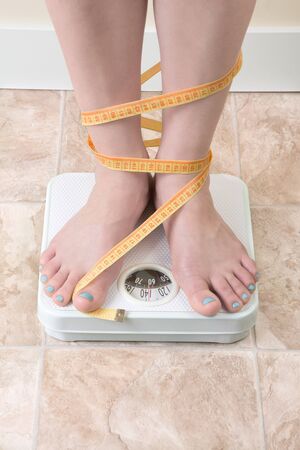 image of woman standing on a weight scaleの写真素材