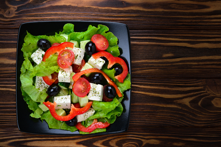 Greek salad on a wooden background. Space for text or design.の写真素材