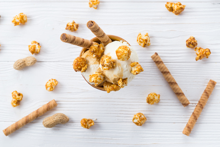 Ice cream with caramel and popcorn on a white table.の写真素材