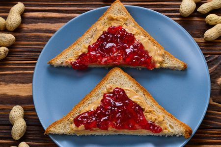 Peanut butter and jelly sandwich on wooden background. Space for text or design.の写真素材