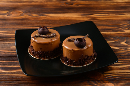 Coffee cakes with caramel and chocolate on a black background. Space for text or design.の写真素材
