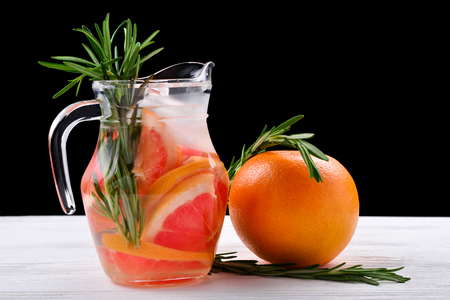 Refreshing summer detox cocktail of grapefruit and rosemary, on wooden table, black background, copy spaceの写真素材