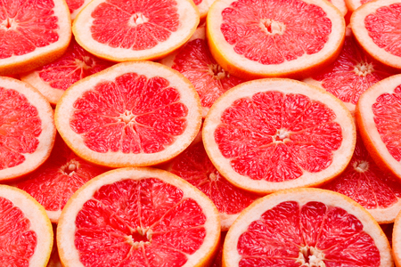 Grapefruit red juicy slices background. top viewの写真素材