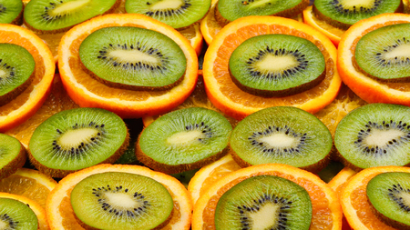 Fruity background set of slices of orange fruit and kiwi. Many slices of kiwi fruit and orange fruit, Fresh kiwis and orange fruit, interesting compositionの写真素材