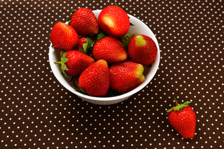 Fresh strawberry in a white plate on table, top view. の写真素材