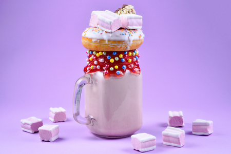 Chocolate extreme milkshake with brownie cake, chocolate paste and sweets. Crazy freakshake food trend. Copy spaceの写真素材