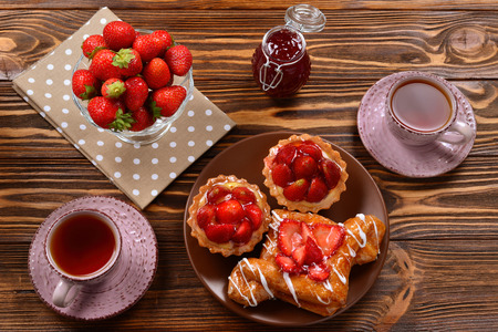 Tea drinking with tartlets and cakes with strawberriesの写真素材