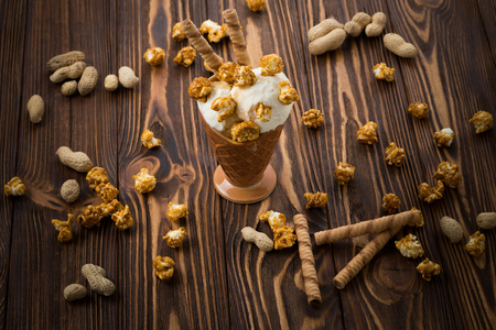 Ice cream with caramel and popcorn on a  black background. Space for text or design.の写真素材