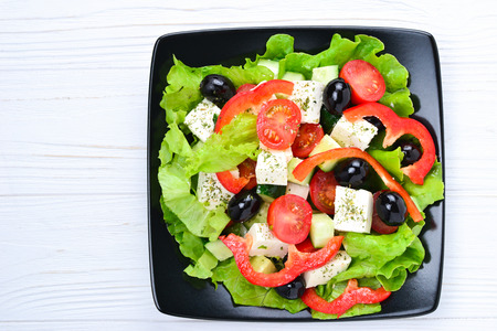 Greek salad on a white wooden background. Space for text or design.の写真素材