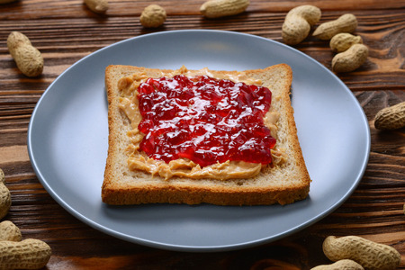 Peanut butter and jelly sandwich on wooden background. Space for text or design.の写真素材