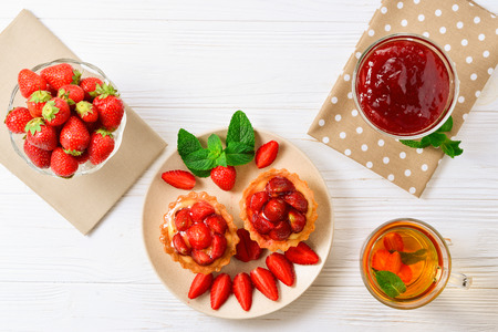 Tea drinking with tartlets and cakes with strawberriesの写真素材