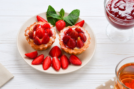 Tea drinking with tartlets and cakes with strawberriesの写真素材
