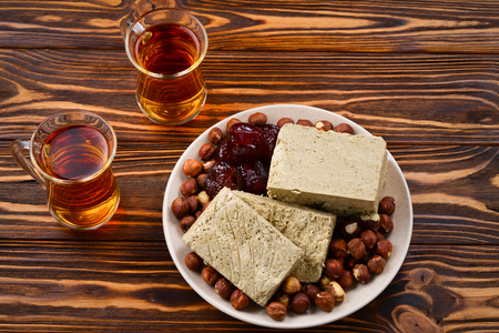 Tasty halva with tea, nuts, dried fruits
 on wooden table の写真素材
