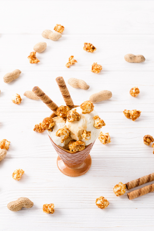 Ice cream with caramel and popcorn on a white table.の写真素材