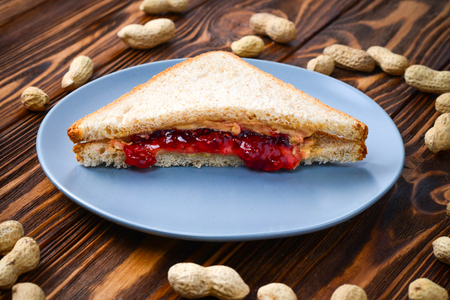 Peanut butter and jelly sandwich on wooden background. Space for text or design.の写真素材