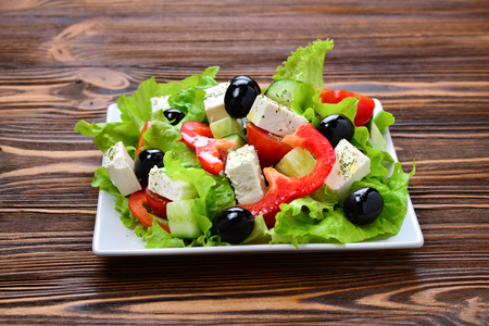 Greek salad on a wooden background. Space for text or design.の写真素材