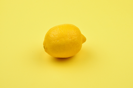 Lemon isolated on yellow background. Space for test or design.の写真素材