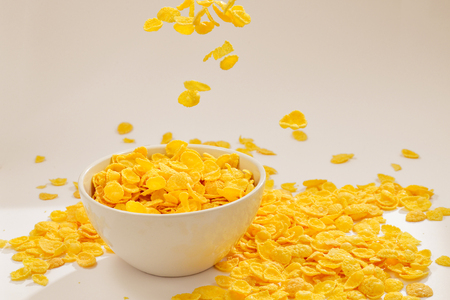 Corn flakes falling to the white bowl. Motion. Copyspace.の写真素材