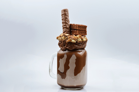 Chocolate extreme milkshake with brownie cake, chocolate paste and sweets. Crazy freakshake food trend. Copy spaceの写真素材