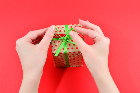 Present in woman hand on red background.の写真素材