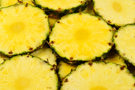 Pineapple juicy yellow slices background. Top view.の写真素材