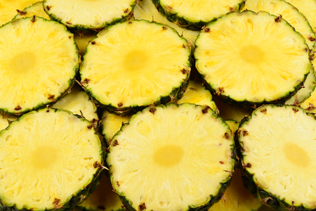Pineapple juicy yellow slices background. Top view.の写真素材