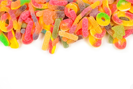 Frame of assorted gummy candies isolated on white. Top view. Space for text or design.の写真素材