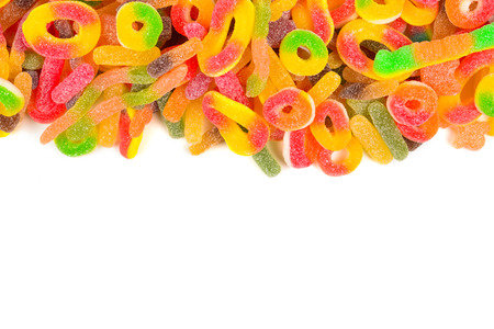 Frame of assorted gummy candies isolated on white. Top view. Space for text or design.の写真素材